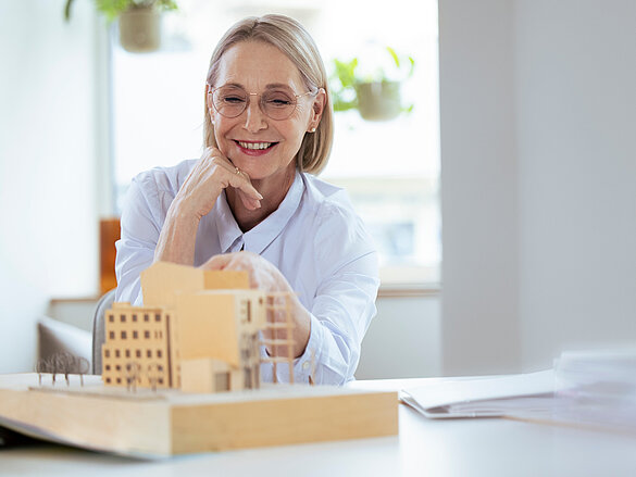 Smiling businesswoman checking model at workplace