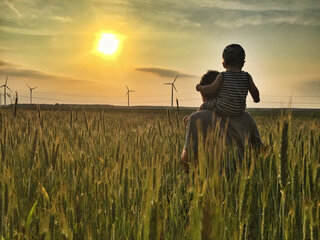 AdobeStock_84922927 Sunset, wheat field, father with child, sustainable, Windmill