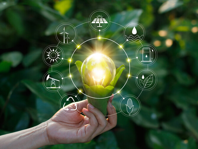 Zehnder_ALL_Energieeffizienz Hand holding light bulb against nature on green leaf with icons energy sources for renewable, sustainable development. Ecology concept. Elements of this image furnished by NASA.
