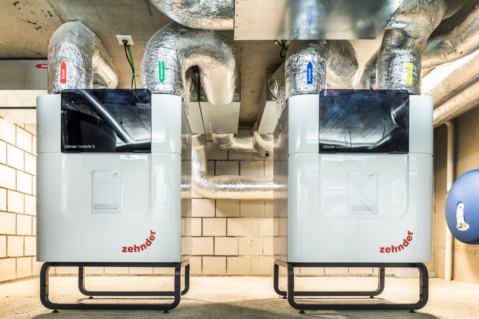 Appareils de ventilation placés de manière centrale dans la cave Deux appareils de ventilation dans la cave d’un immeuble collectif